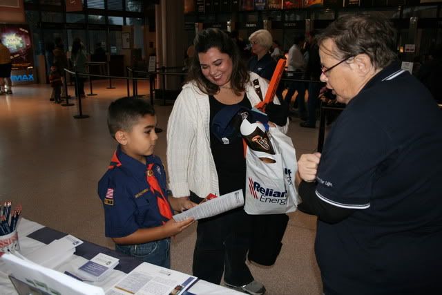 Volunteer Colette Ming discusses blood donation with young boy scout, Joey Perez, and his mom Nereyda Perez